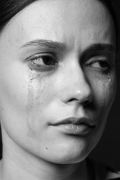 Photo of Sad woman crying on dark background, closeup. Black and white effect