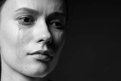 Photo of Sad woman crying on dark background, closeup. Black and white effect