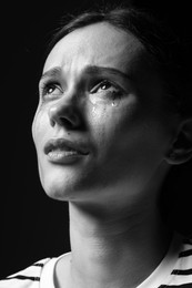 Photo of Sad woman crying on dark background. Black and white effect