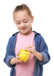 Photo of Little girl putting her pocket money into piggy bank on white background