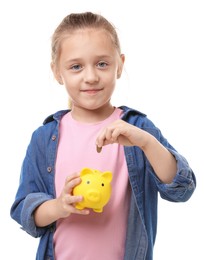Photo of Little girl putting her pocket money into piggy bank on white background