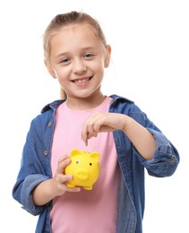 Photo of Little girl putting her pocket money into piggy bank on white background