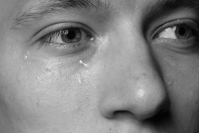 Photo of Closeup view of sad man crying. Black and white effect