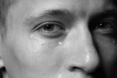 Photo of Closeup view of sad man crying. Black and white effect