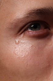Photo of Closeup view of sad young man crying