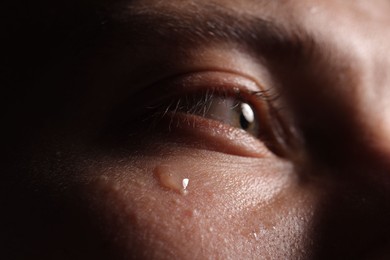 Photo of Closeup view of sad young man crying