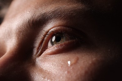 Photo of Closeup view of sad young man crying