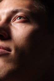 Photo of Closeup view of sad young man crying