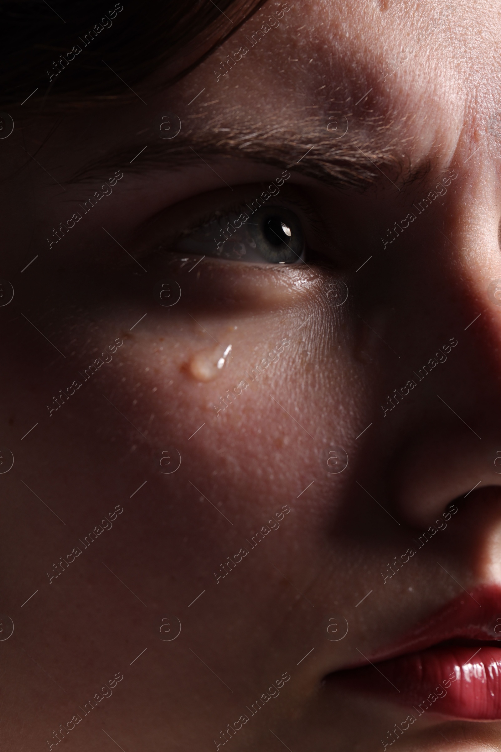 Photo of Closeup view of sad young woman crying