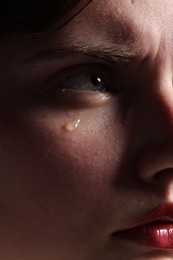 Photo of Closeup view of sad young woman crying