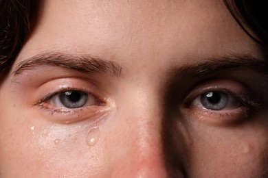 Photo of Closeup view of sad young woman crying