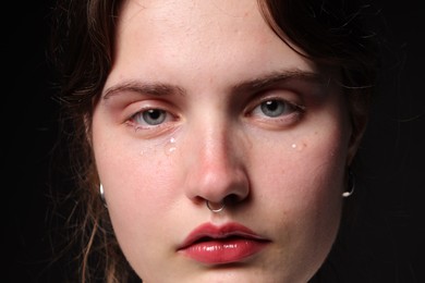 Photo of Sad woman crying on black background, closeup