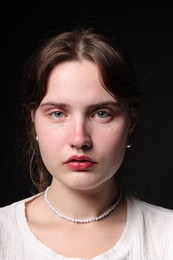 Photo of Sad young woman crying on black background