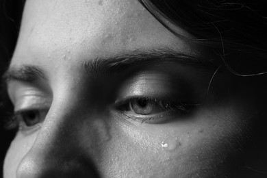 Photo of Closeup view of sad young woman crying. Black and white effect