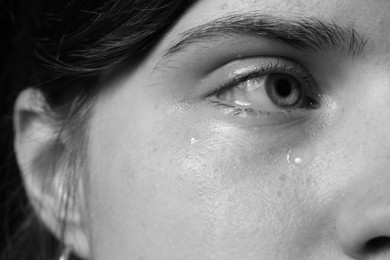 Photo of Closeup view of sad young woman crying. Black and white effect