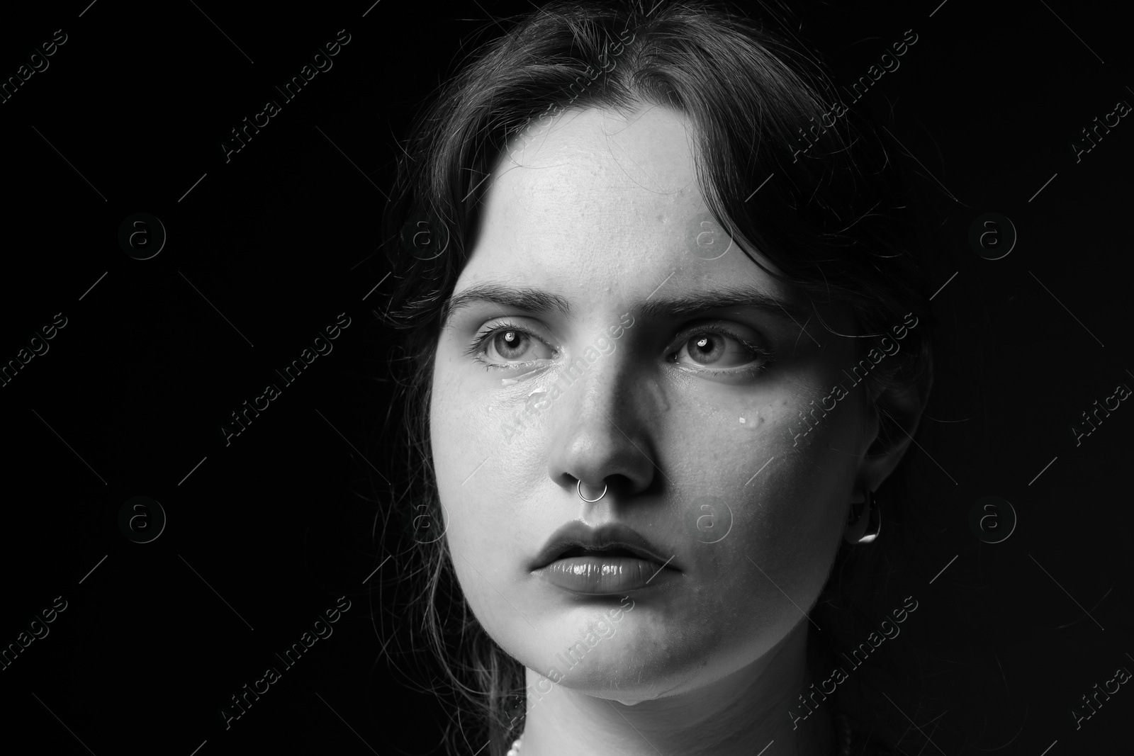 Photo of Sad woman crying on dark background. Black and white effect
