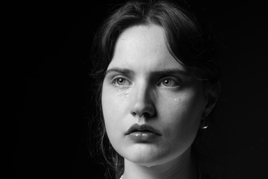 Photo of Sad woman crying on dark background. Black and white effect