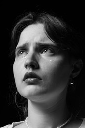 Photo of Sad woman crying on dark background. Black and white effect