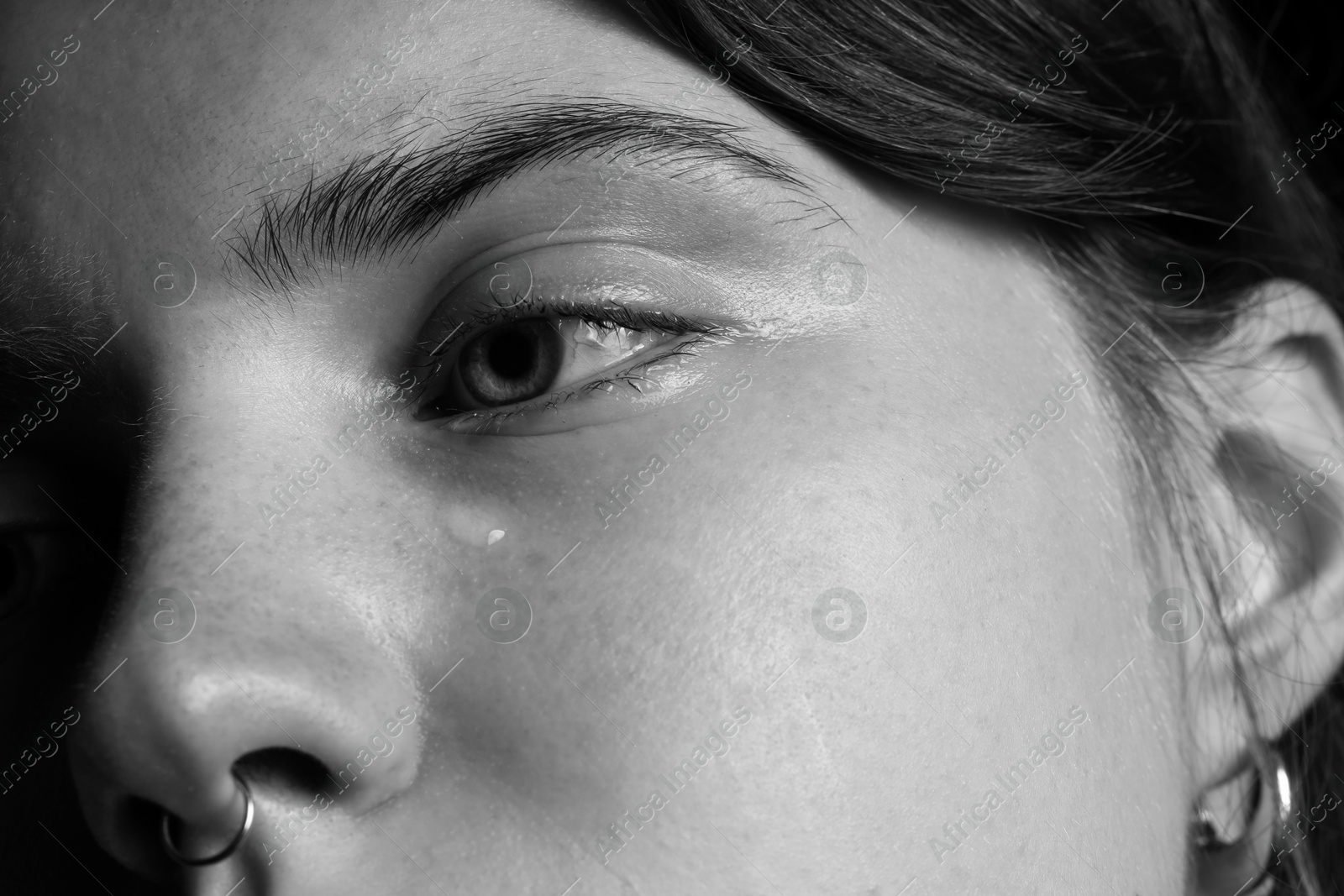 Photo of Closeup view of sad young woman crying. Black and white effect