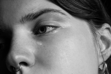 Photo of Closeup view of sad young woman crying. Black and white effect