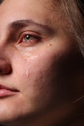 Photo of Closeup view of sad young woman crying