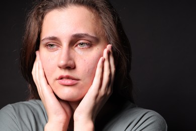 Photo of Sad young woman crying on black background