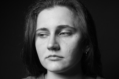 Photo of Sad woman crying on dark background. Black and white effect