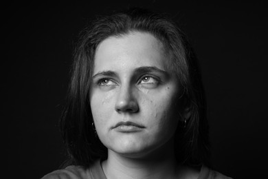 Photo of Sad woman crying on dark background. Black and white effect