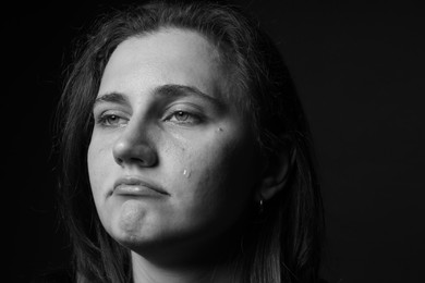 Photo of Sad woman crying on dark background. Black and white effect