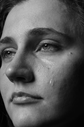 Photo of Closeup view of sad young woman crying. Black and white effect