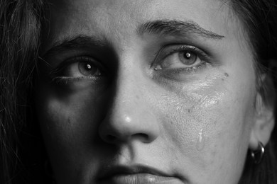 Photo of Closeup view of sad young woman crying. Black and white effect