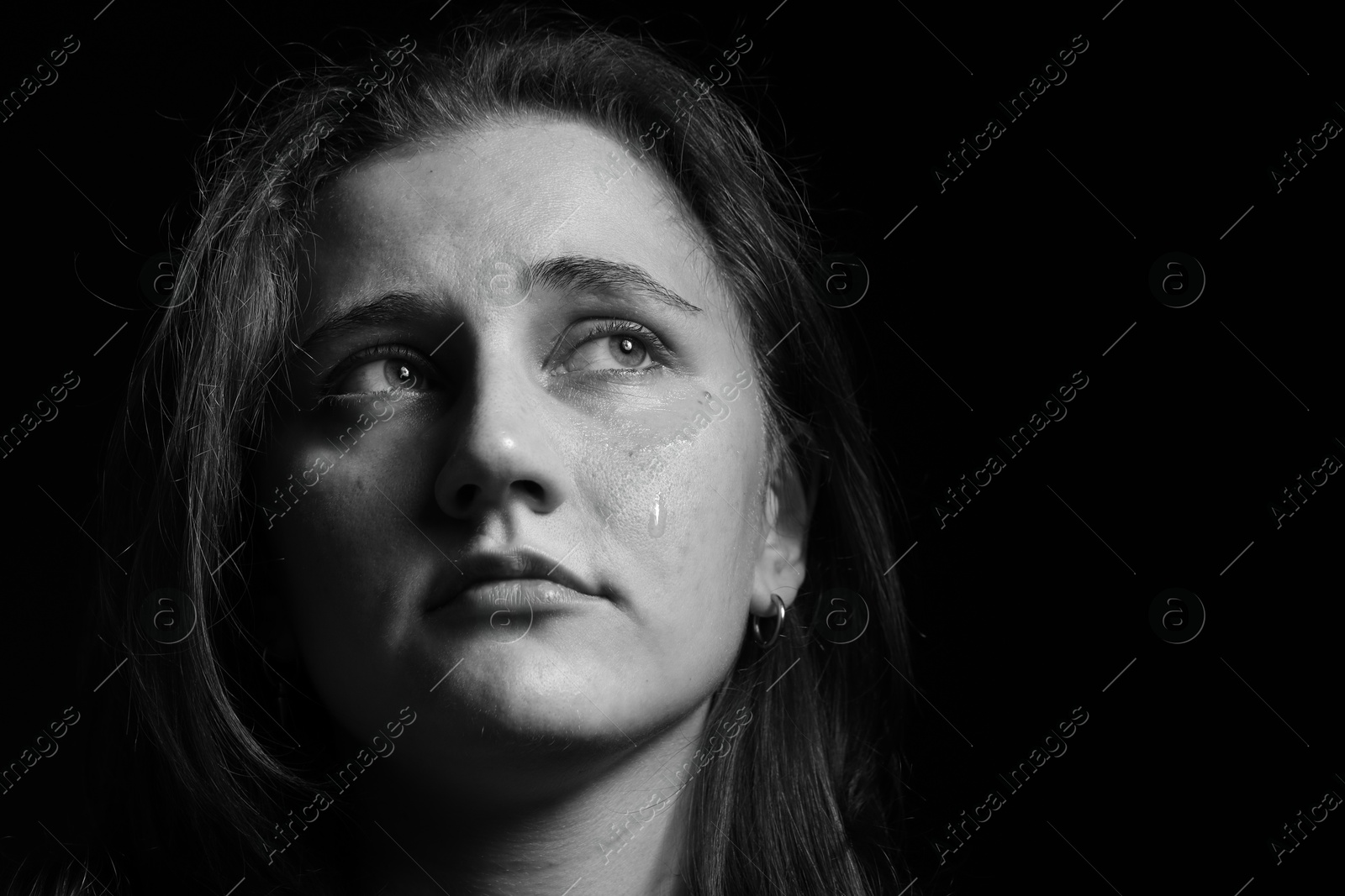 Photo of Sad woman crying on dark background. Black and white effect