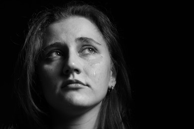 Photo of Sad woman crying on dark background. Black and white effect