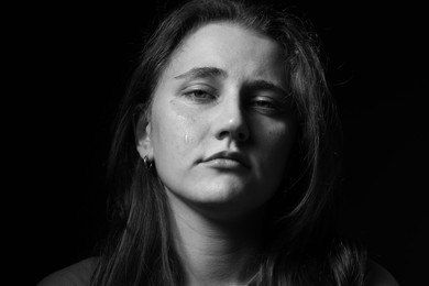 Photo of Sad woman crying on dark background. Black and white effect