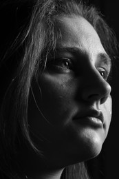 Photo of Sad woman crying on dark background, closeup. Black and white effect
