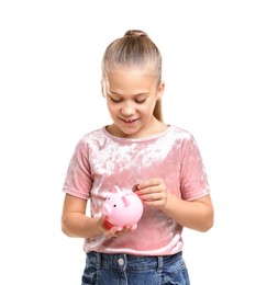 Photo of Little girl putting her pocket money into piggy bank on white background