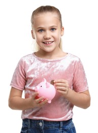 Photo of Little girl putting her pocket money into piggy bank on white background