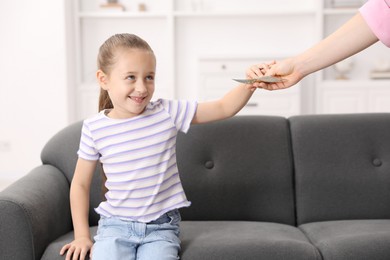 Photo of Mother giving her daughter pocket money at home, closeup