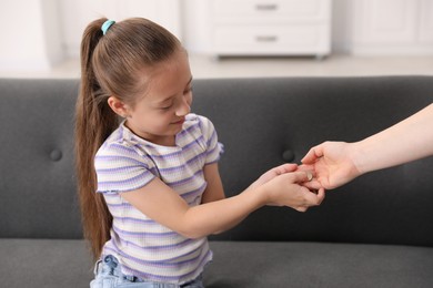 Photo of Mother giving her daughter pocket money at home, closeup