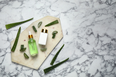 Flat lay composition with aloe vera and cosmetic products on white marble background. Space for text