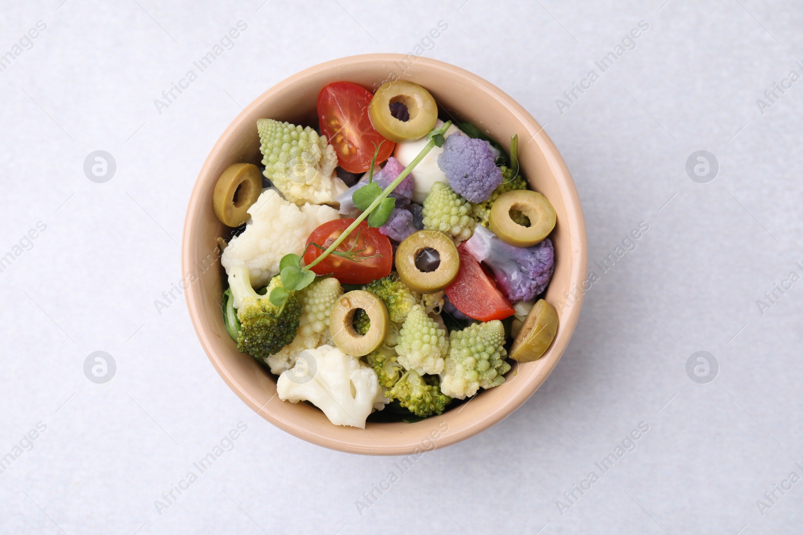 Photo of Delicious salad with cauliflower, tomato and olives on white table, top view