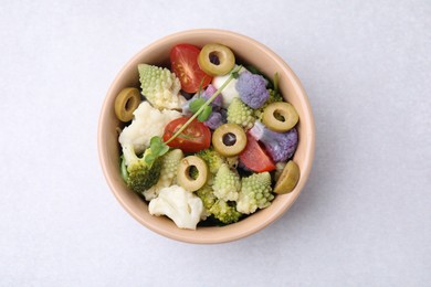 Delicious salad with cauliflower, tomato and olives on white table, top view