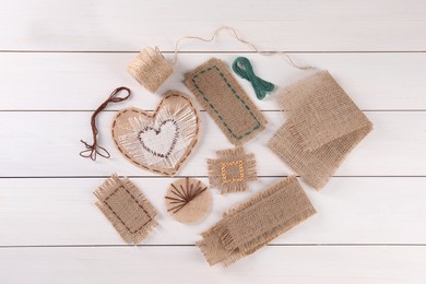 Photo of Flat lay composition with pieces of burlap fabric on white wooden table