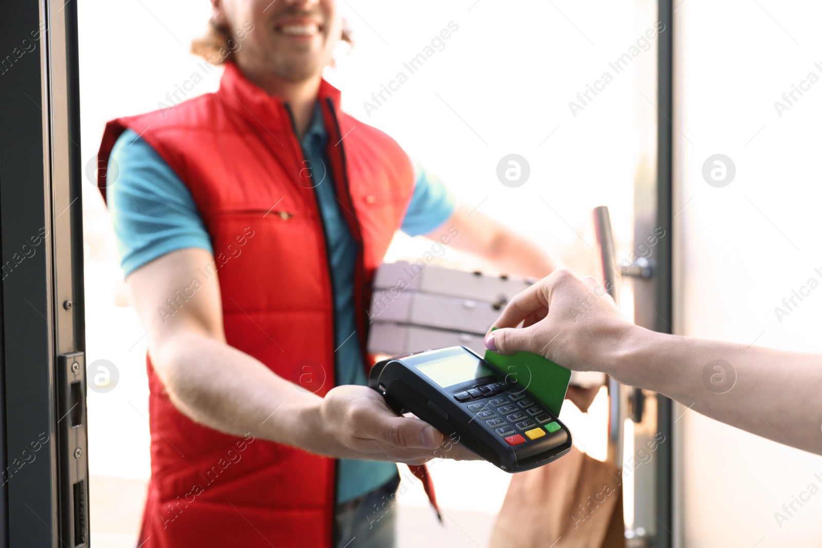 Photo of Woman paying for food delivery with credit card at door, closeup