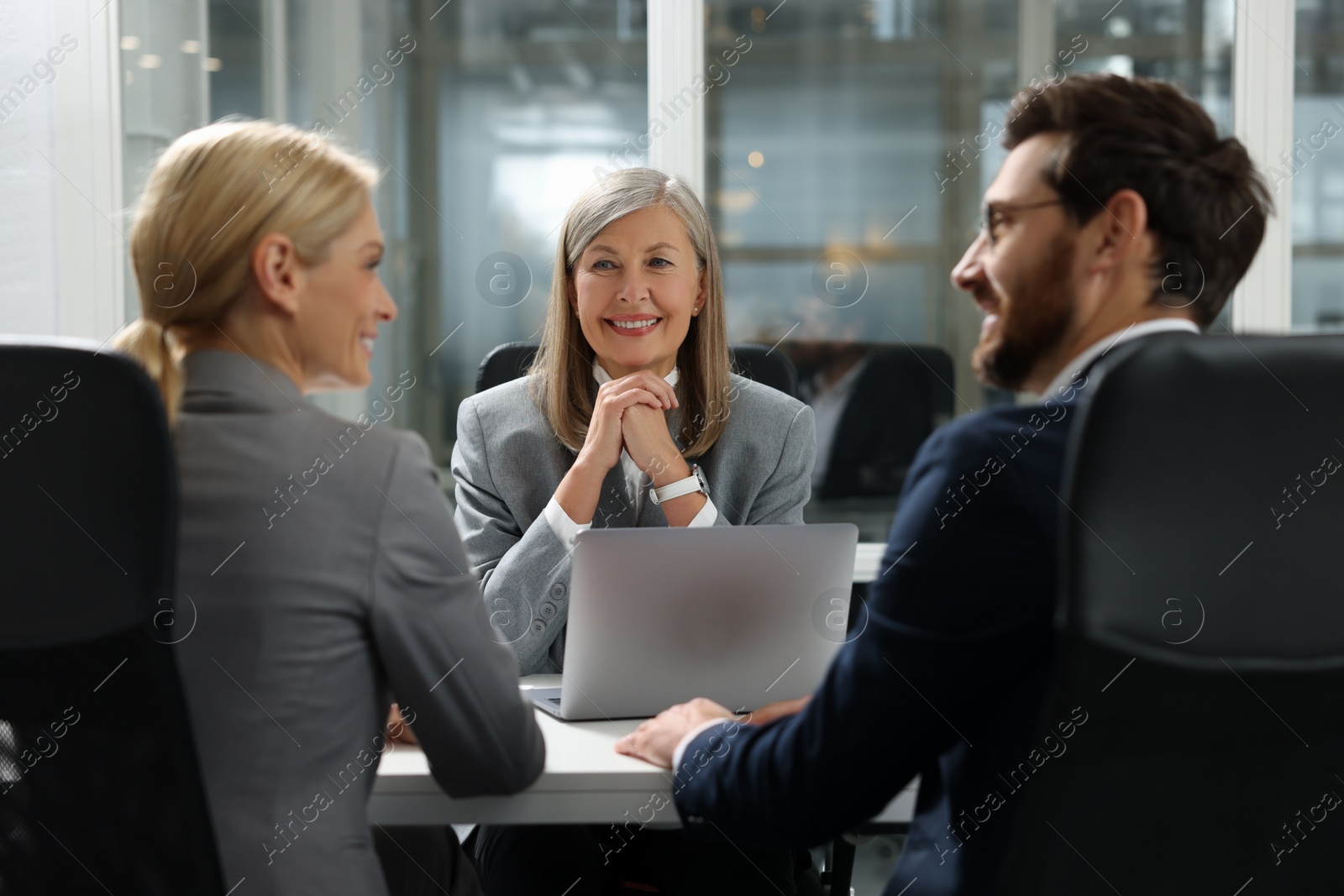 Photo of Lawyer working with clients at table in office