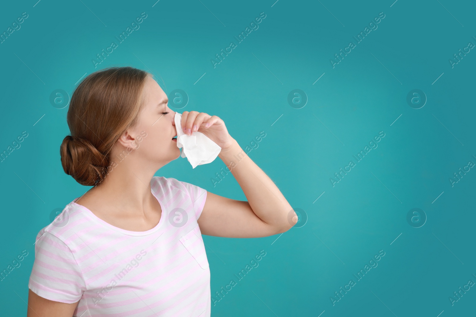 Photo of Young woman suffering from allergy on turquoise background. Space for text