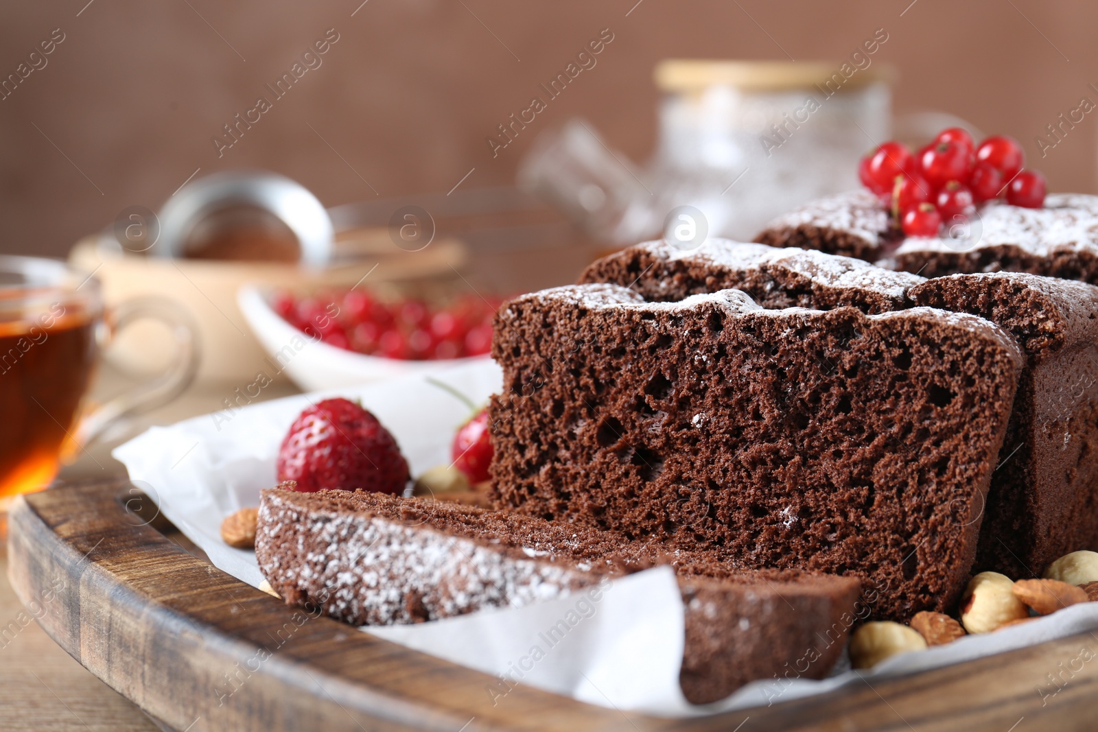 Photo of Tasty chocolate sponge cake with nuts and berries on table, closeup