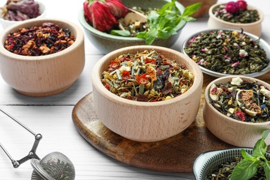 Photo of Many different herbal teas on white wooden table