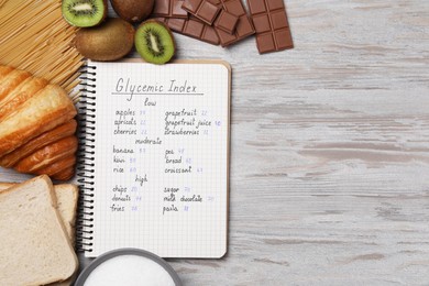 Photo of Flat lay composition with products of low, moderate and high glycemic index near food on light wooden table. Space for text