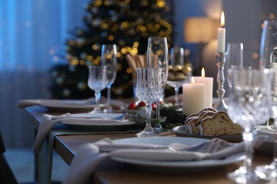 Photo of Christmas table setting with festive decor and dishware indoors